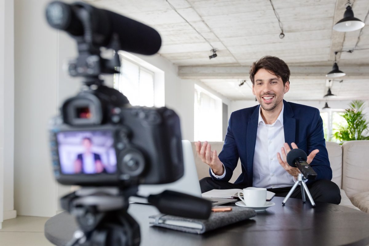 A man in a suit recording a video