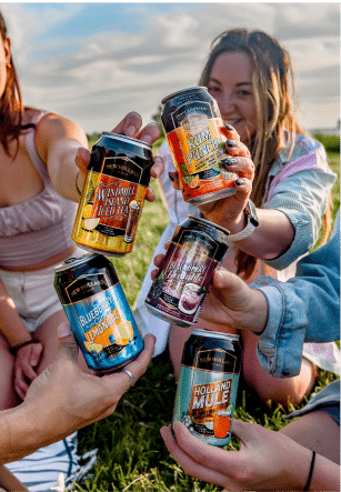 Two cans of New Holland Craft Cocktails being held up for the camera