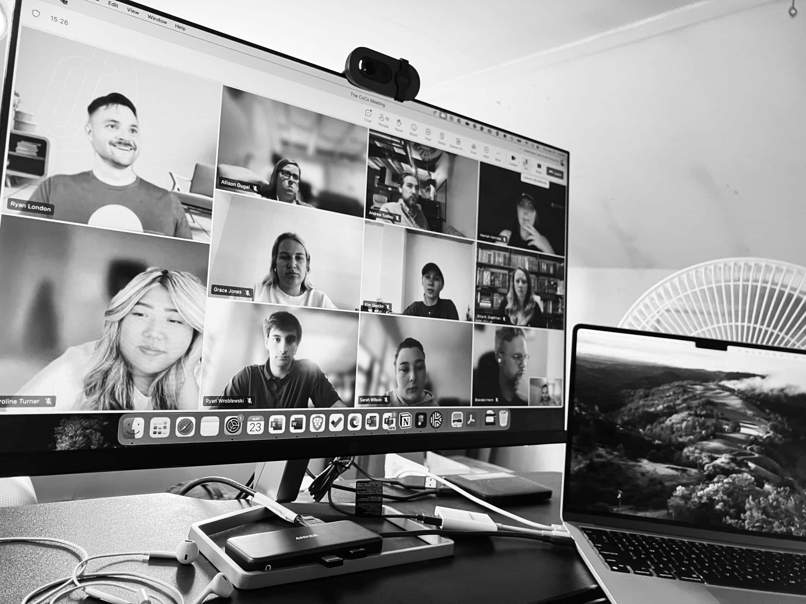 A work from home setup featuring a large monitor with a laptop to the right of it